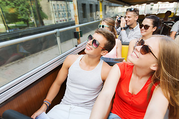 Image showing group of smiling friends traveling by tour bus