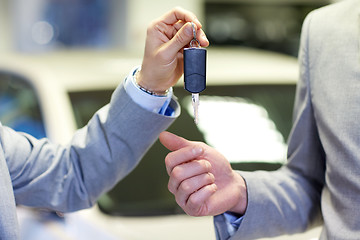 Image showing close up of male hands with car key in auto salon