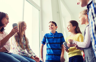 Image showing group of school kids with soda cans in corridor