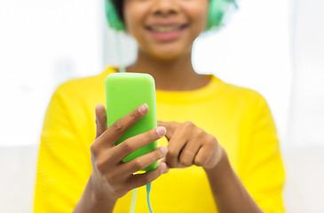 Image showing happy african woman with smartphone and headphones