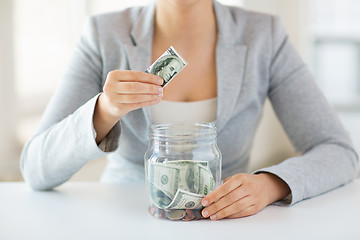 Image showing close up of woman hands and dollar money in jar