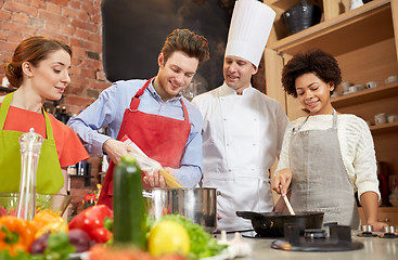 Image showing happy friends and chef cook cooking in kitchen