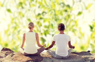 Image showing smiling couple making yoga exercises outdoors