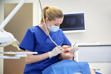 Image showing female dentist checking patient girl teeth