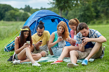 Image showing friends with smartphone and tent at camping