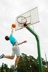 Image showing young man playing basketball outdoors