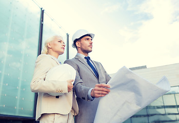 Image showing businessmen with blueprint and helmets