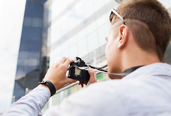 Image showing close up of young man with digital camera in city