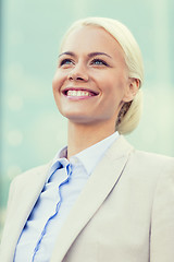 Image showing young smiling businesswoman over office building