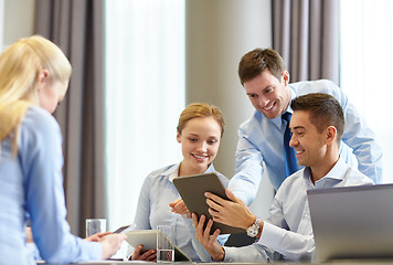 Image showing smiling business people with tablet pc in office