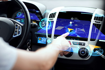 Image showing male hand using navigation system on car dashboard