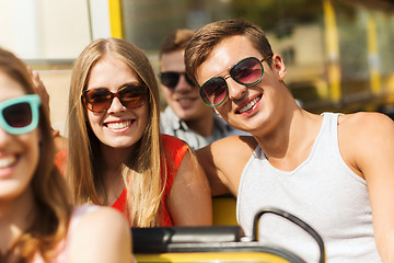 Image showing group of smiling friends traveling by tour bus