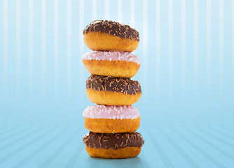 Image showing close up of glazed donuts pile over blue