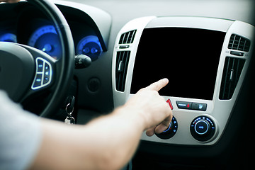 Image showing male hand pointing finger to monitor on car panel