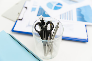 Image showing close up of cup with scissors and pens at office