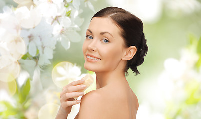 Image showing woman with soap bar over cherry blossom background