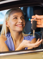 Image showing happy woman getting car key in auto show or salon