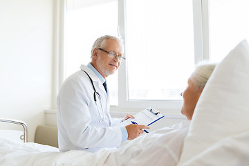 Image showing senior woman and doctor with clipboard at hospital