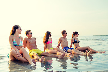 Image showing smiling friends in sunglasses on summer beach