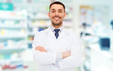 Image showing smiling male pharmacist in white coat at drugstore