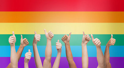 Image showing hands showing thumbs up over rainbow background