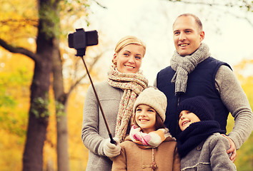 Image showing happy family with smartphone and monopod in park