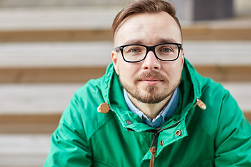 Image showing happy young hipster man sitting on stairs in city