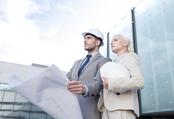 Image showing businessmen with blueprint and helmets