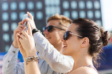 Image showing smiling friends with smartphone taking picture