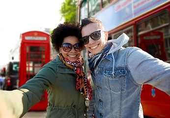 Image showing happy teenage couple taking selfie in london city