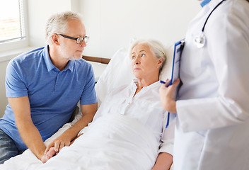 Image showing senior woman and doctor with clipboard at hospital