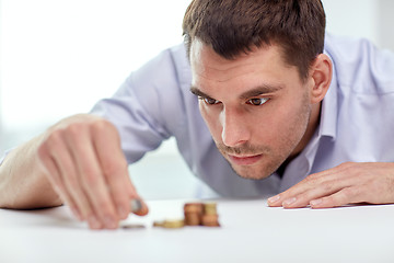 Image showing businessman with coins at office