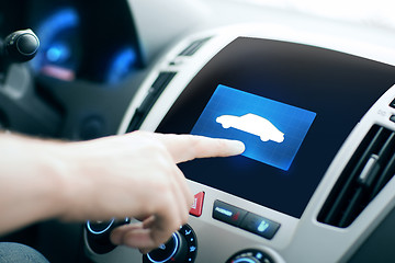 Image showing male hand pointing finger to car icon on panel