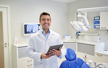 Image showing happy male dentist with tablet pc at dental clinic