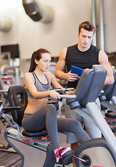 Image showing woman with trainer on exercise bike in gym