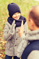 Image showing happy father and son making high five in park