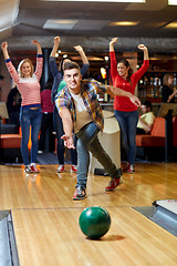 Image showing happy young man throwing ball in bowling club