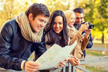 Image showing group of friends with map and camera outdoors