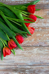 Image showing close up of red tulips on wooden background