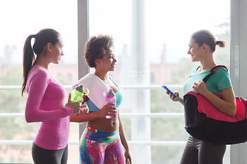 Image showing happy women with bottles of water in gym