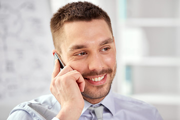 Image showing young smiling businessman calling on smartphone