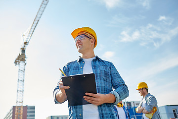 Image showing builder in hardhat with clipboard at construction