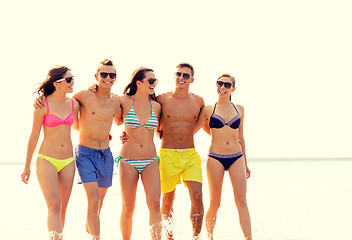 Image showing smiling friends in sunglasses on summer beach