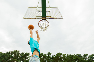 Image showing young man playing basketball outdoors