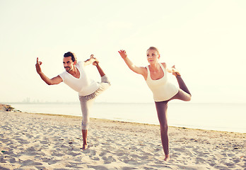 Image showing couple making yoga exercises outdoors