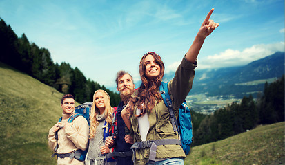 Image showing group of smiling friends with backpacks hiking