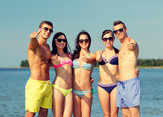 Image showing smiling friends in sunglasses on summer beach