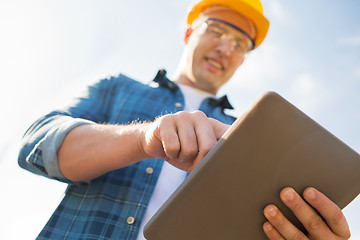 Image showing close up of builder in hardhat with tablet pc