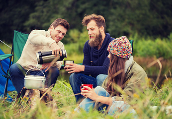 Image showing group of smiling friends cooking food outdoors