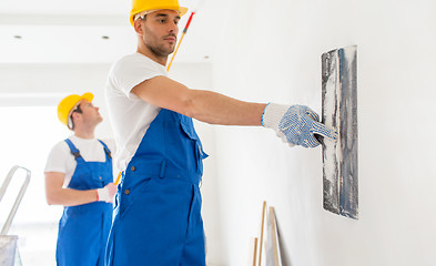 Image showing two builders with painting tools repairing room